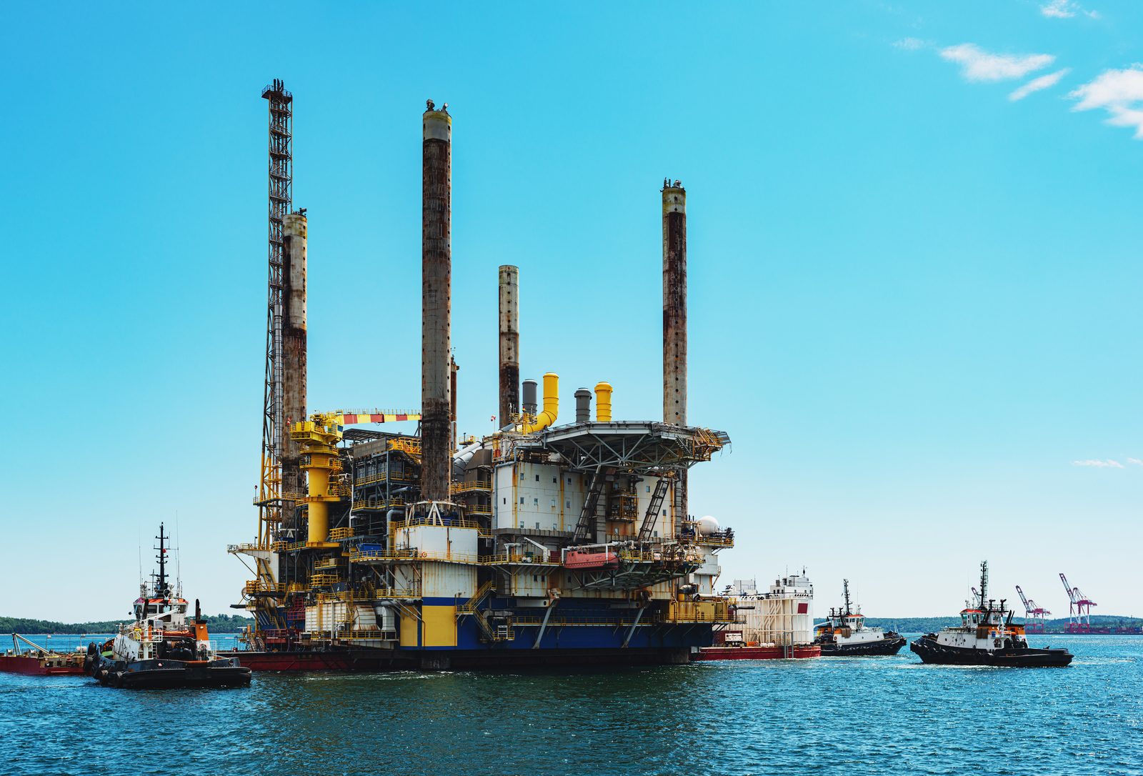Offshore platform with yellow boats in turquoise water